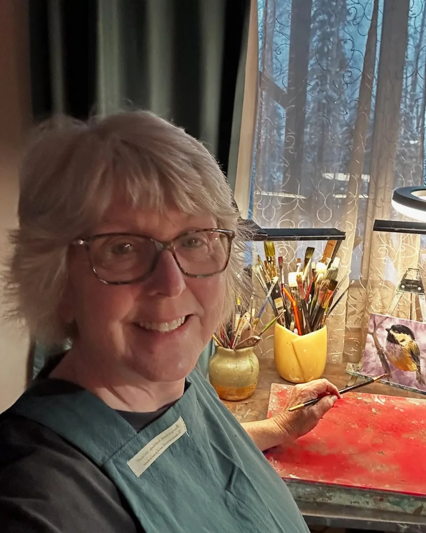 A Hanee community member painting in a green apron